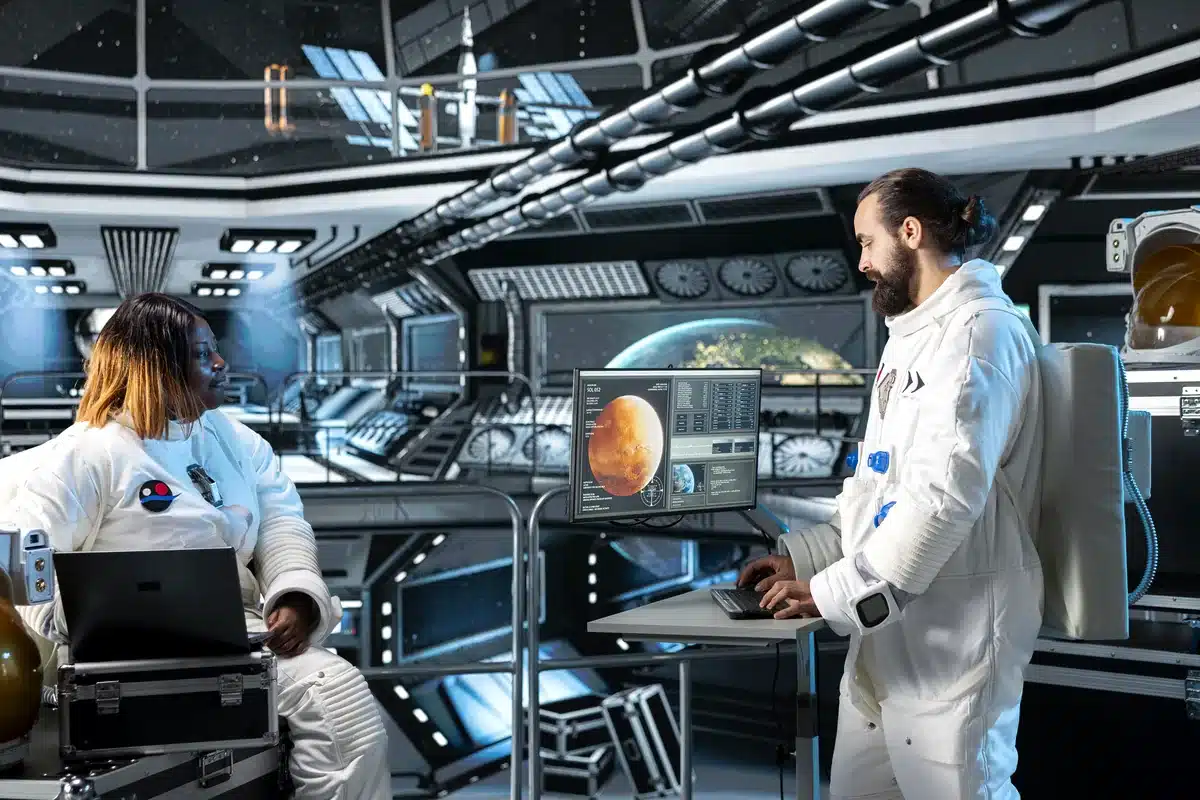 Ilustración de dos astronautas que trabajan con computadoras en una nave, con Marte y la Tierra en las pantallas