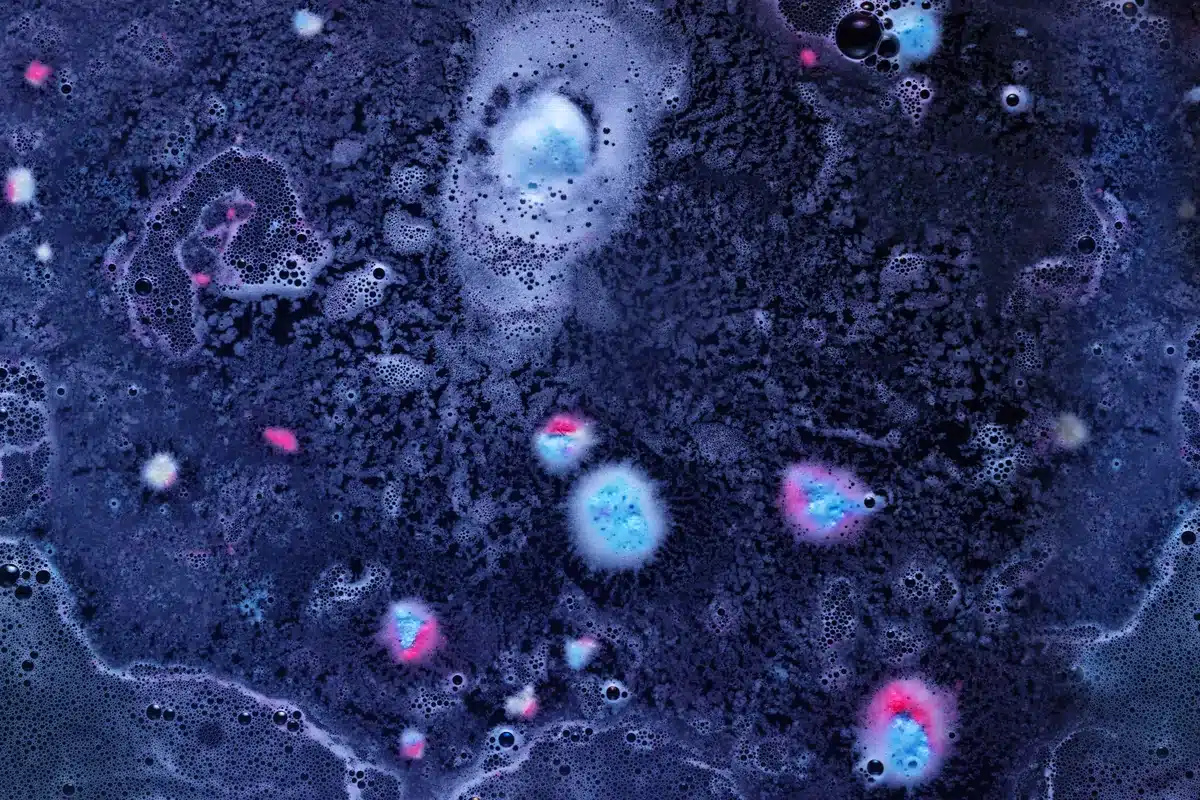Imagen abstracta en tonos azules y violetas con manchas circulares rosadas y celestes