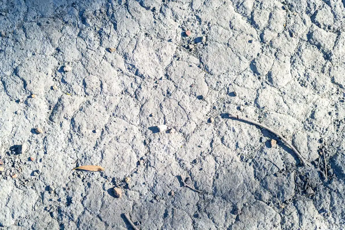 Primer plano de un suelo gris, agrietado y polvoriento