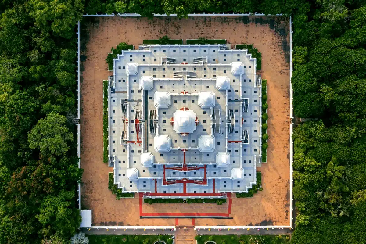 Vista aérea de un edificio blanco con cúpulas rodeado de jardines y selva
