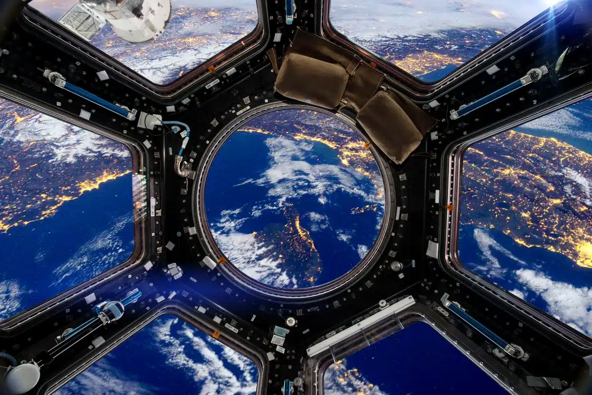 La Tierra de noche vista a través de las ventanas de la cúpula de la Estación Espacial Internacional