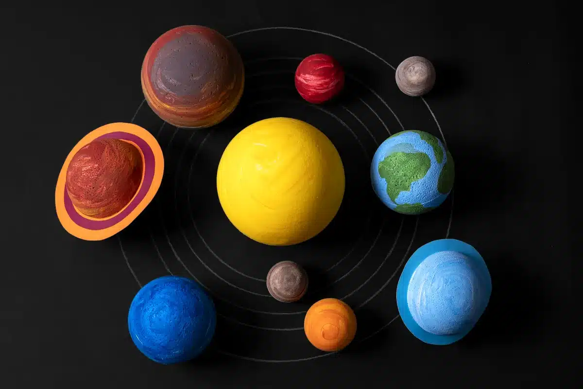 Modelos de los planetas del sistema solar alrededor de un Sol amarillo sobre un fondo negro
