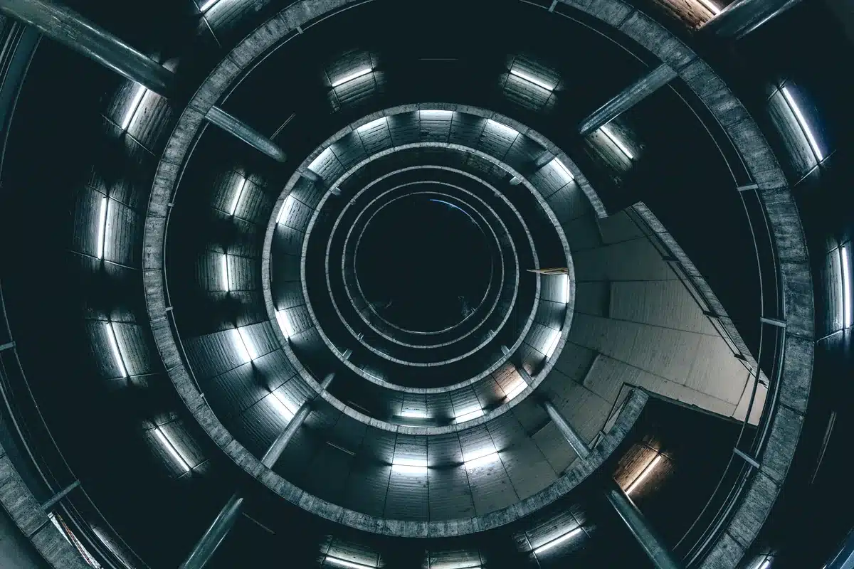 Interior circular de una estructura con anillos concéntricos iluminados, visto desde abajo