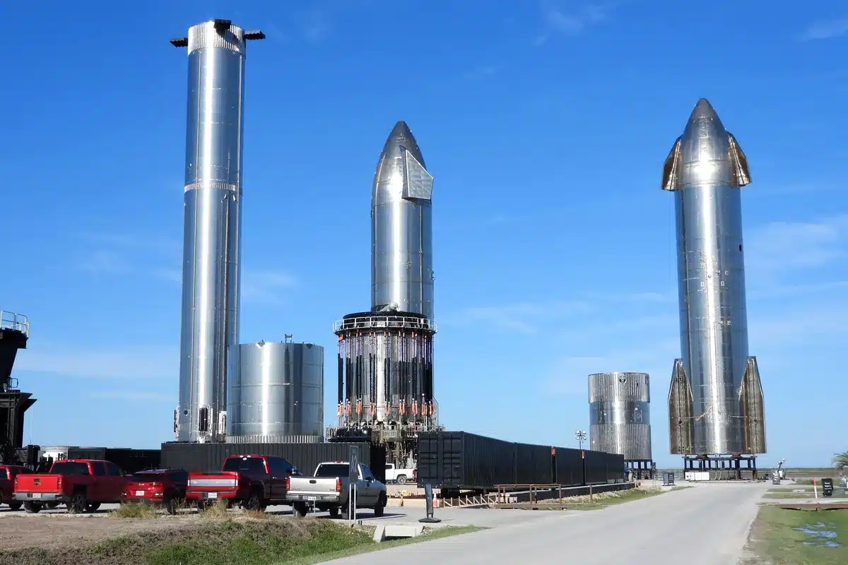 Prototipos de Starship y tanques de acero inoxidable en una base, con camionetas estacionadas