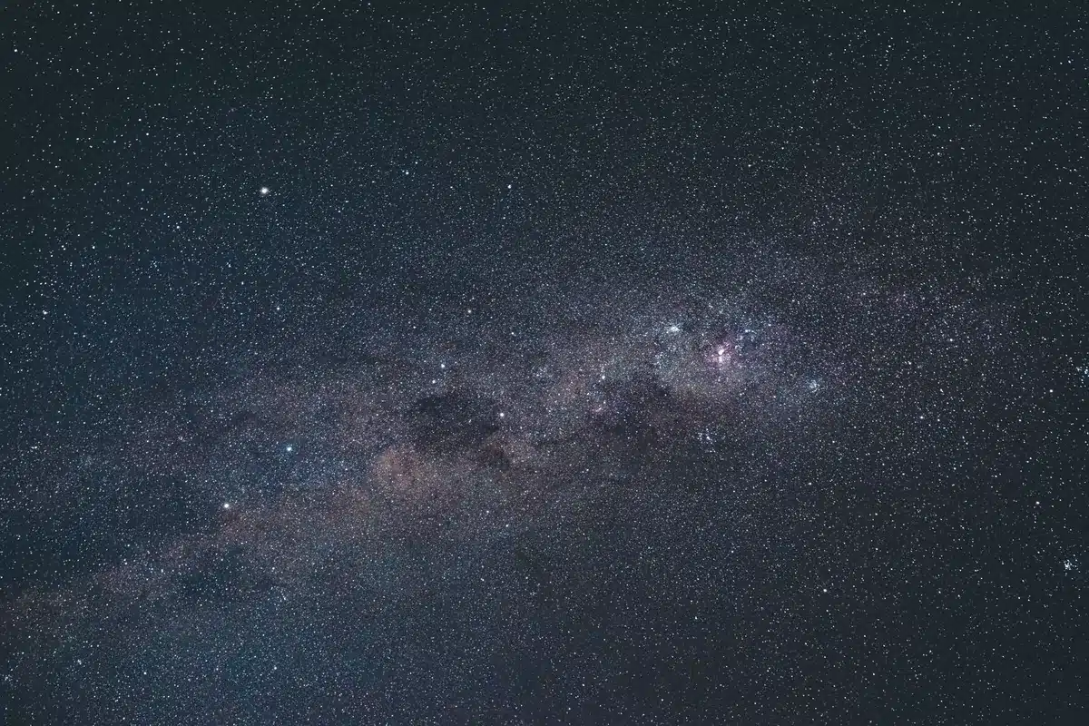 Cielo nocturno estrellado atravesado por la franja de la Vía Láctea