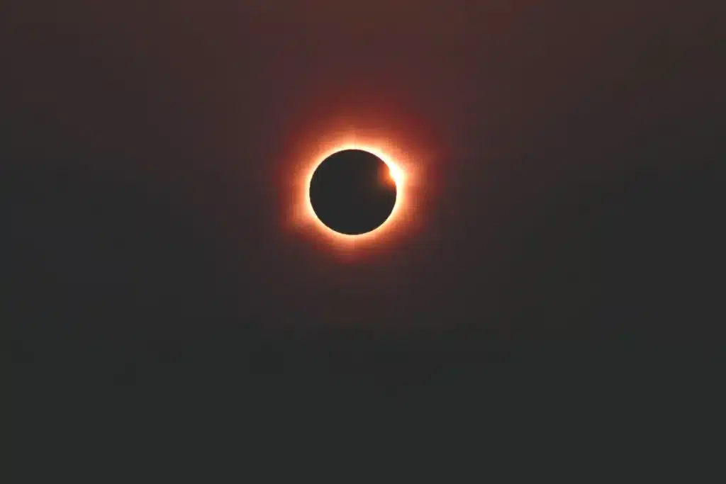 total solar eclipse corona visible over ocean horizon dramatic sky no people