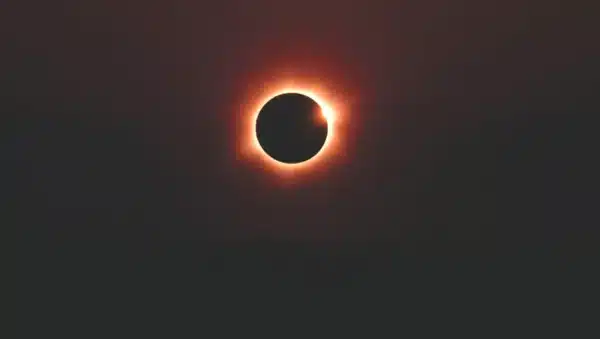 total solar eclipse corona visible over ocean horizon dramatic sky no people