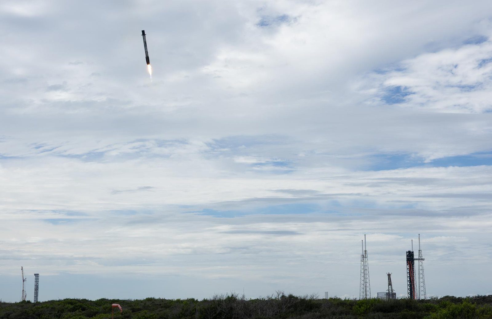 La primera etapa de un Falcon 9 desciende con el motor encendido sobre la costa de Cabo Cañaveral