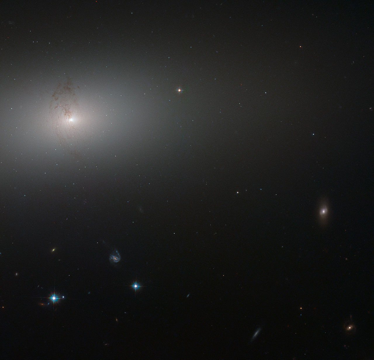 Núcleo brillante de una galaxia elíptica, cuya luz se desvanece hacia fuera en un halo blanquecino sobre fondo oscuro