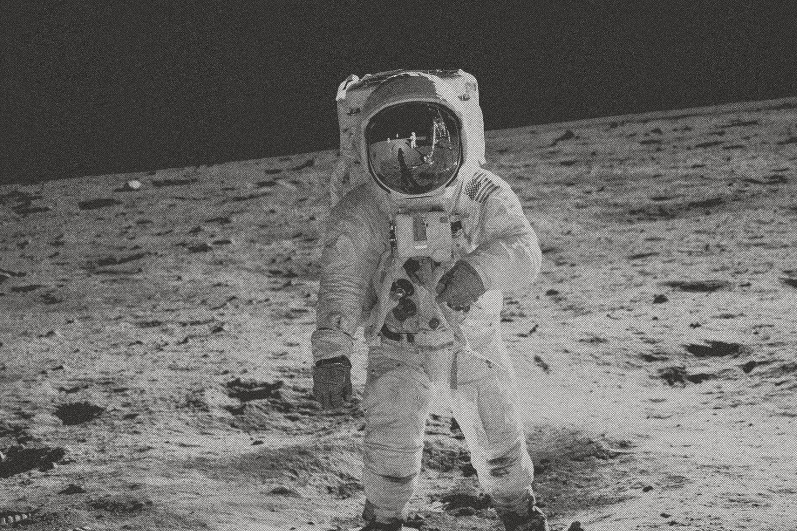 Astronauta con traje espacial de pie sobre la superficie lunar, en blanco y negro