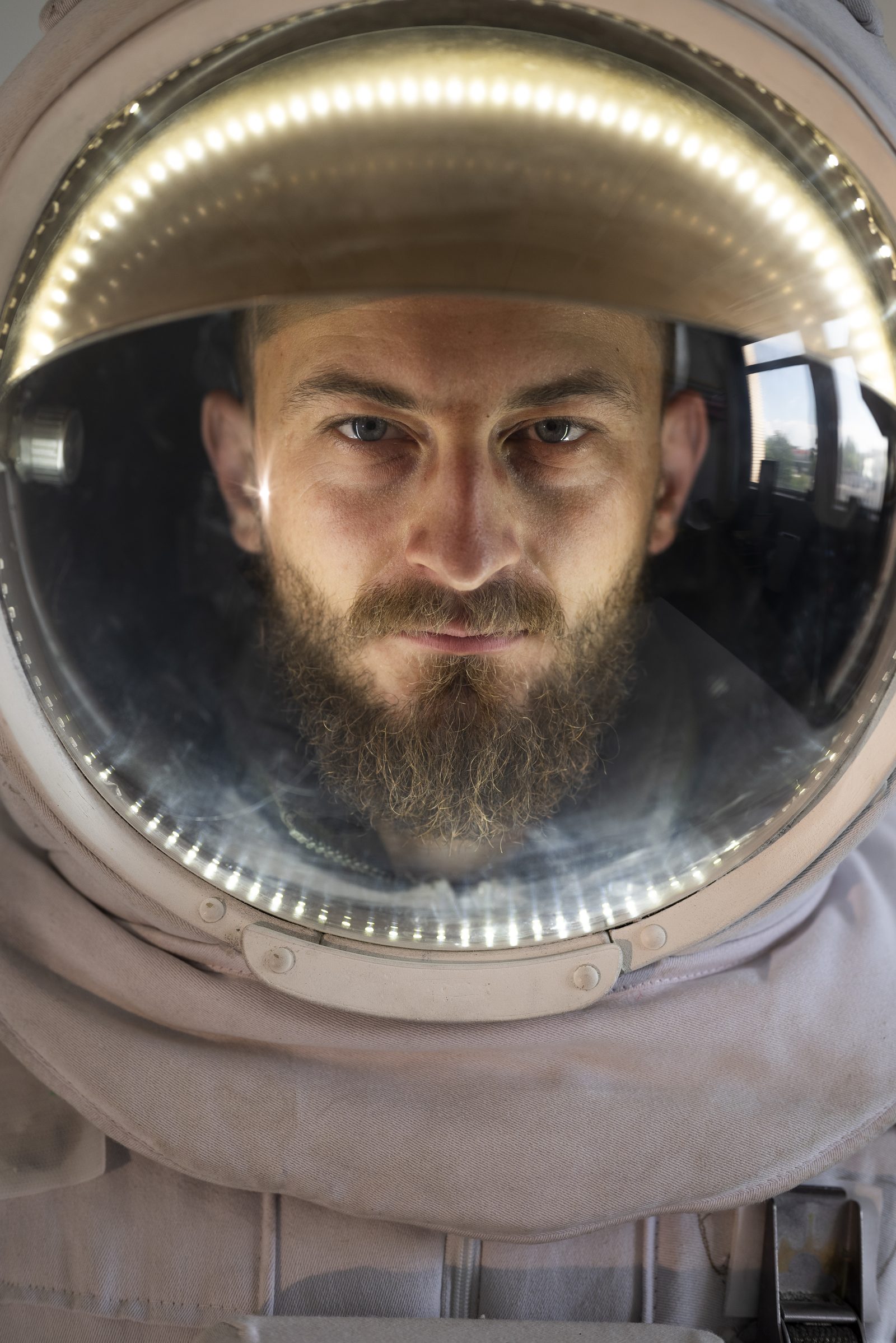 Retrato de un hombre con barba dentro de un casco de astronauta